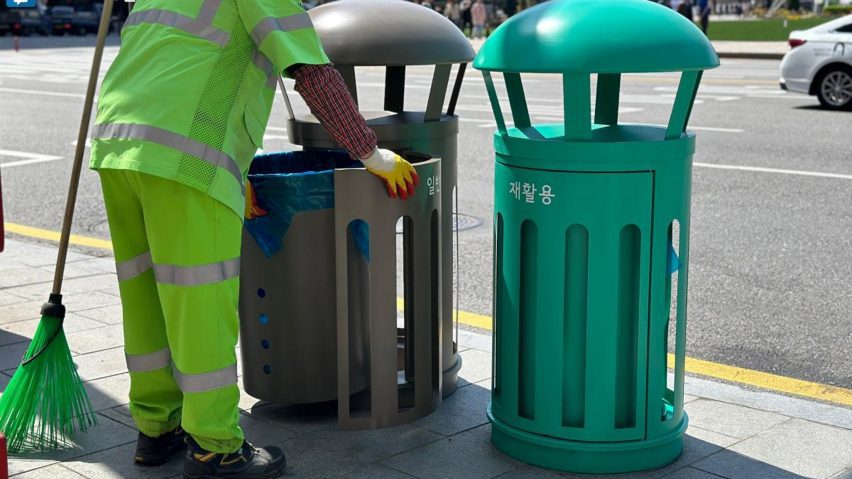 Man removing rubbish from street bin