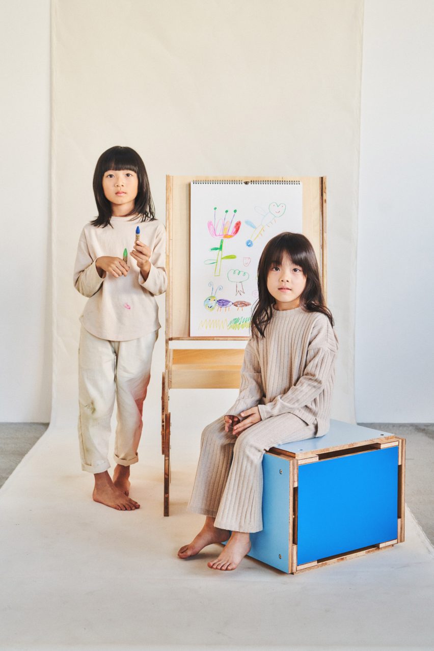 Two girls next to an easle and stool by Woset