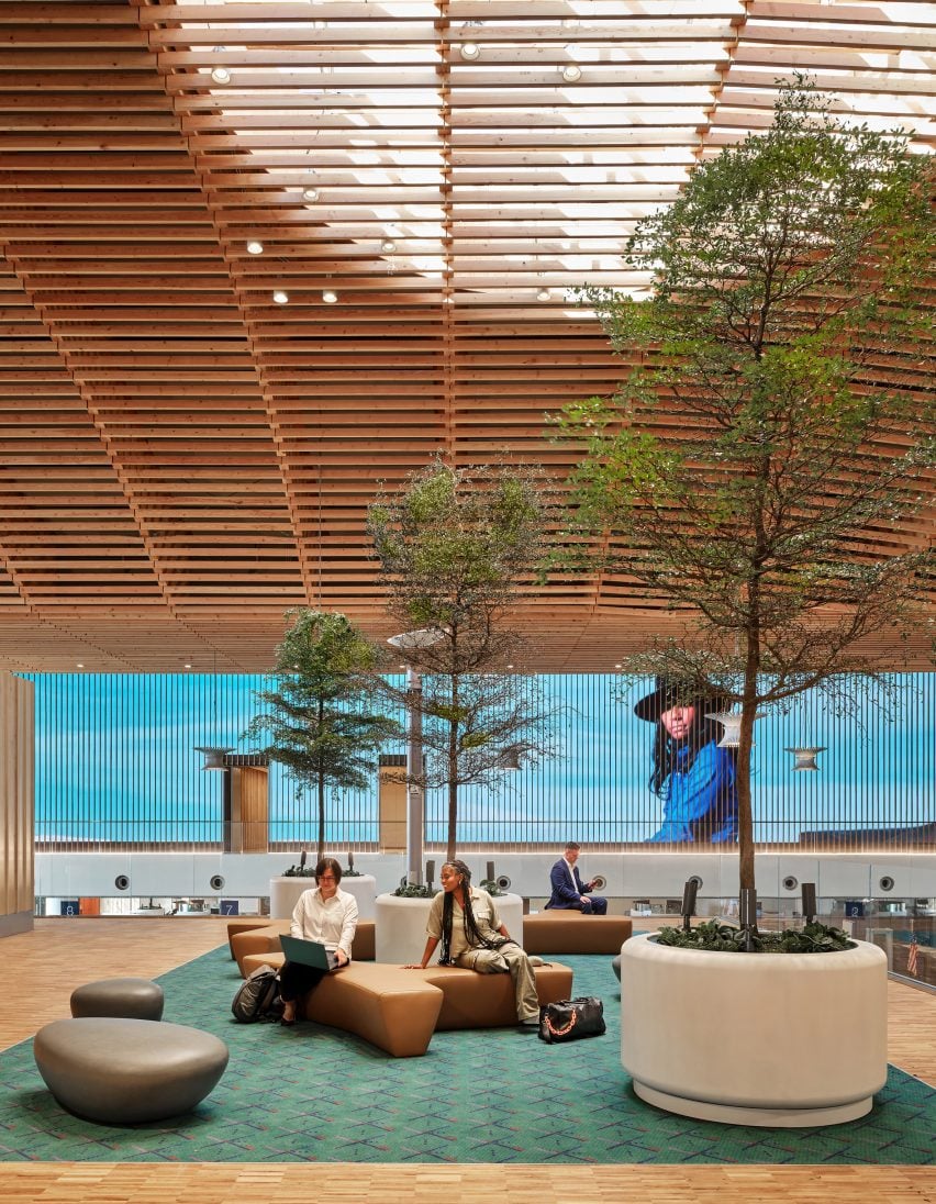 Two people sitting under trees at Portland wooden airport terminal