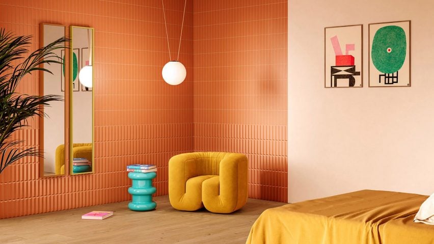 A bright orange and yellow bedroom interior, with a mustard yellow armchair and a hanging spheric lamp. Artwork and mirrors are hanging on the walls.