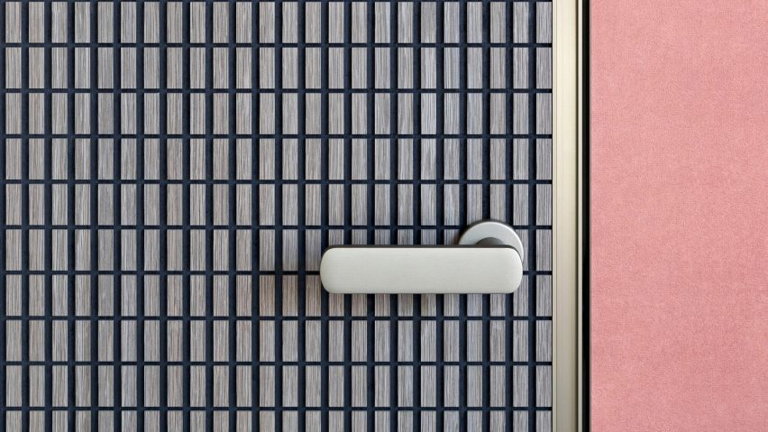 Close-up photograph of a section of a door. The door has a raised grid pattern and is set between a pink wall.