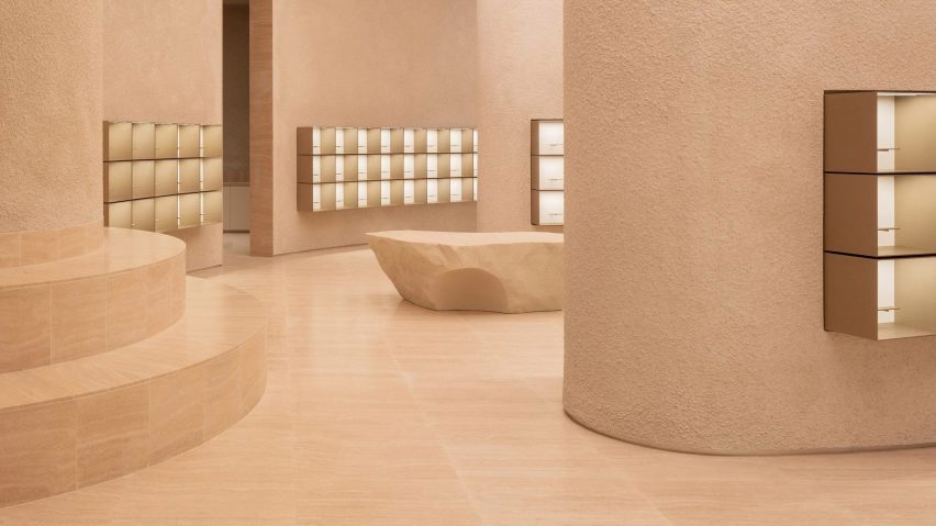 Photograph of a minimalist sand coloured shop interior with curved walls.