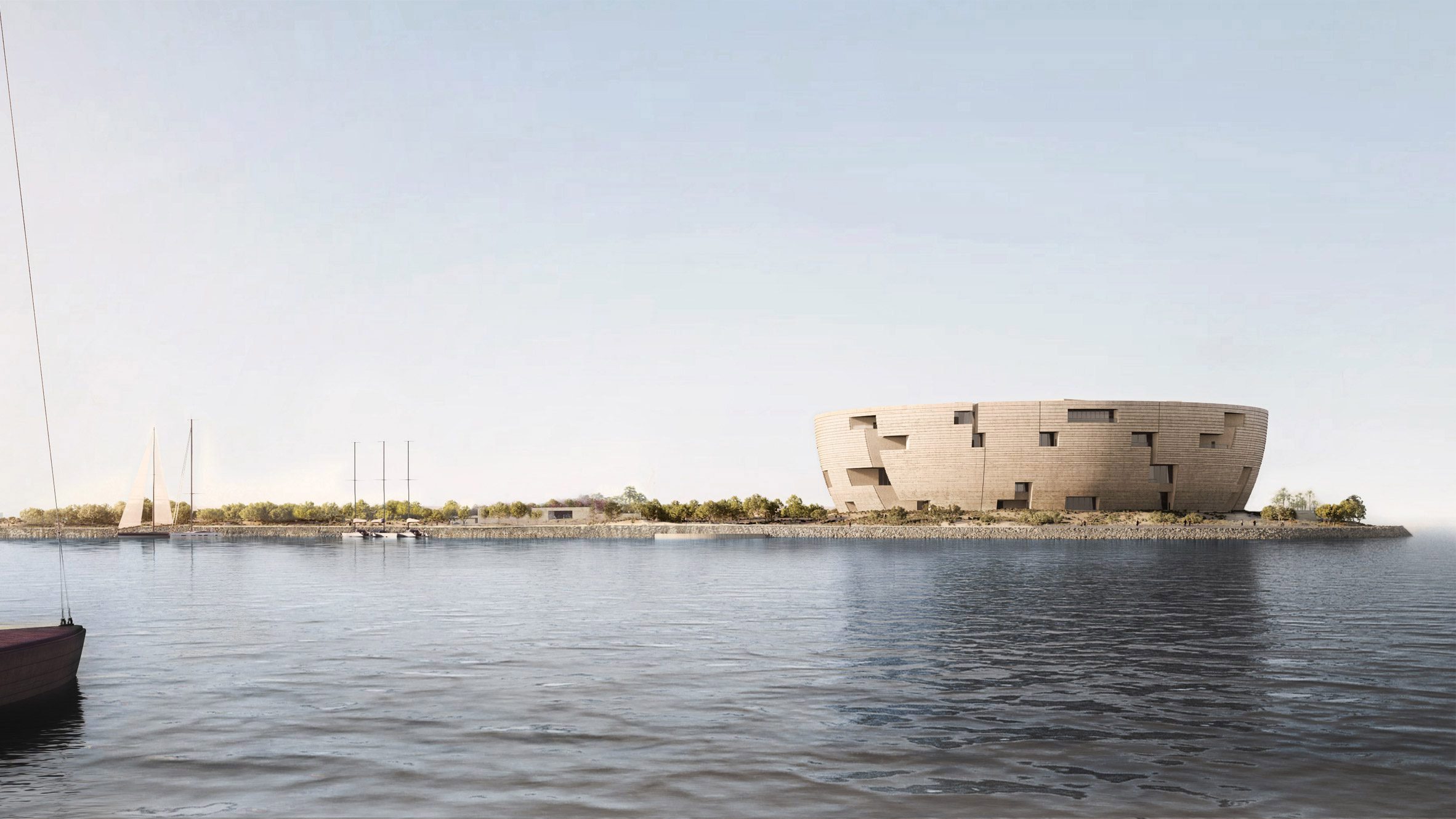 Realistic visualisation of a circular, drum-shaped museum made from sand coloured stone. The view is across a bay of water.