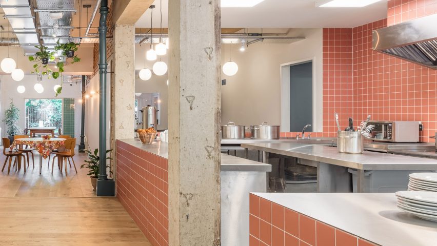 Photograph of an open plan interior showing a kitchen with peach coloured tiles.