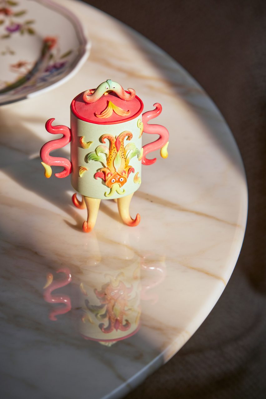 A photograph of a green and orange snuff pot designed by Lim, decorated with an enchanted creature from Chinese mythology.