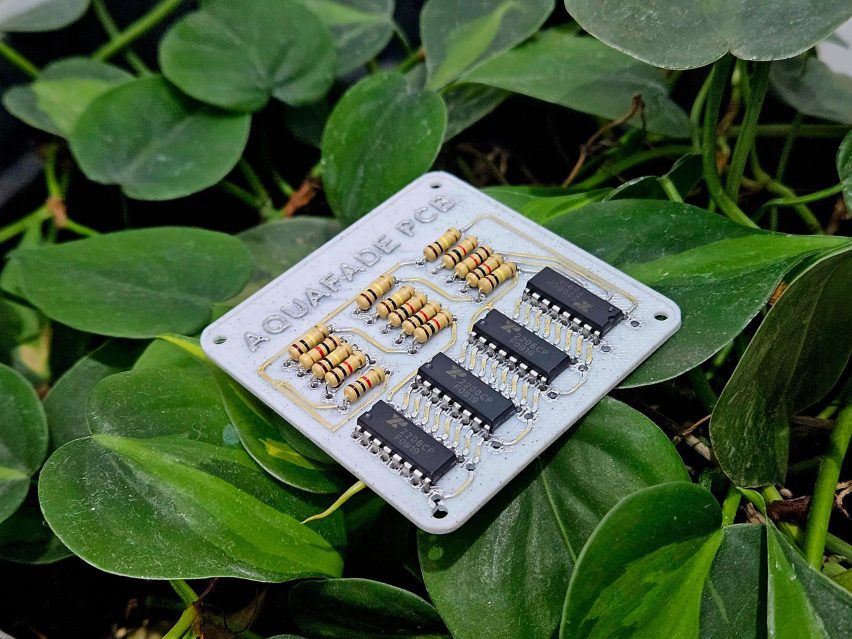 Photo of an Aquafade PCB board resting on some greenery