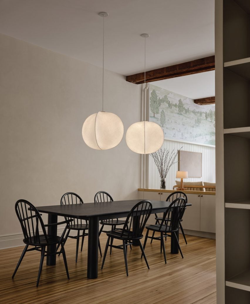 Dining room with large black table and six windsor chairs