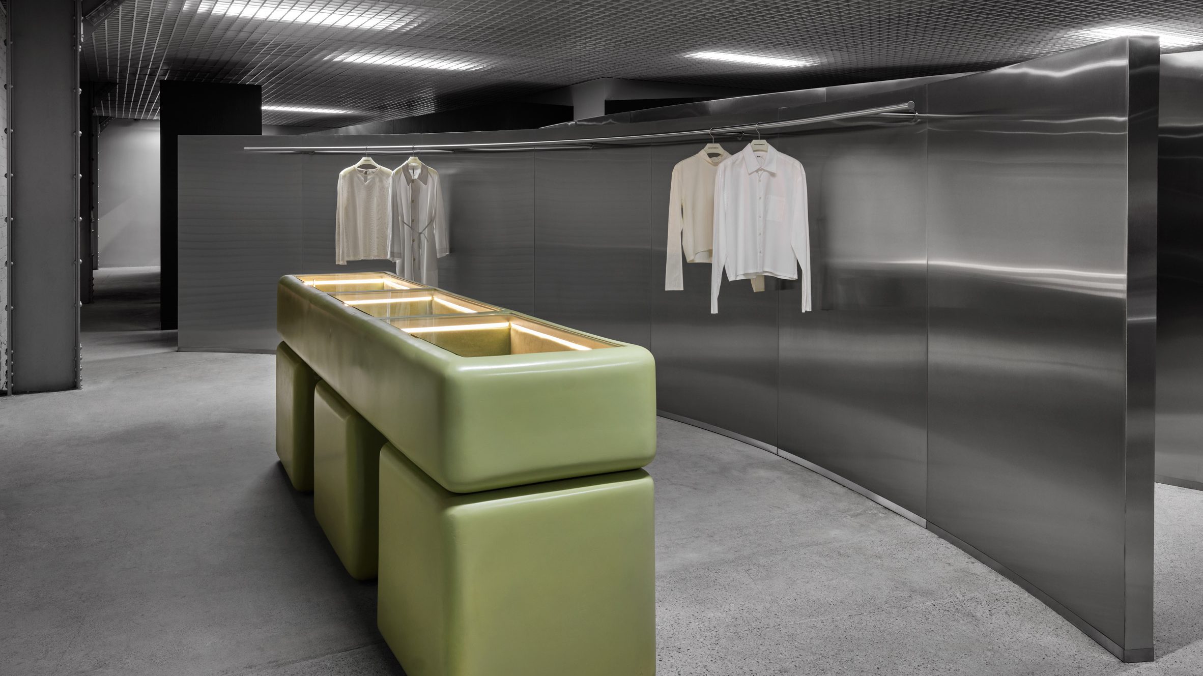 Menswear boutique with metal apparel display and green jewellery case