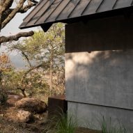 Black roof overhangs with concrete wall