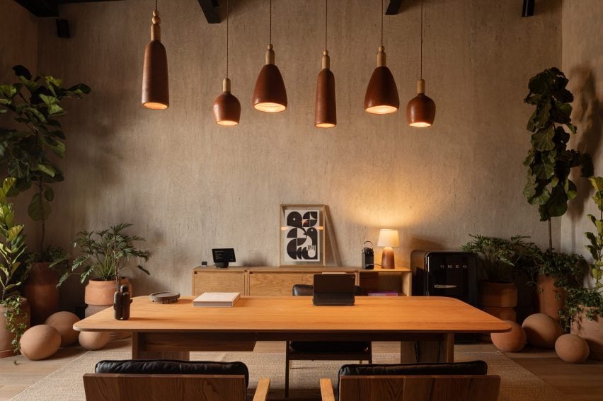 Meeting room with a variety of clay lights and pots, plus wooden furniture