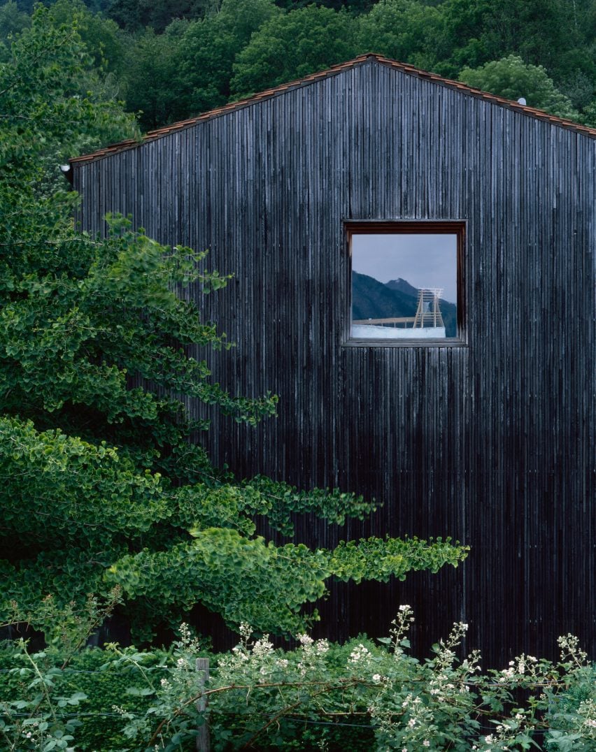 Black wooden clad house end with window