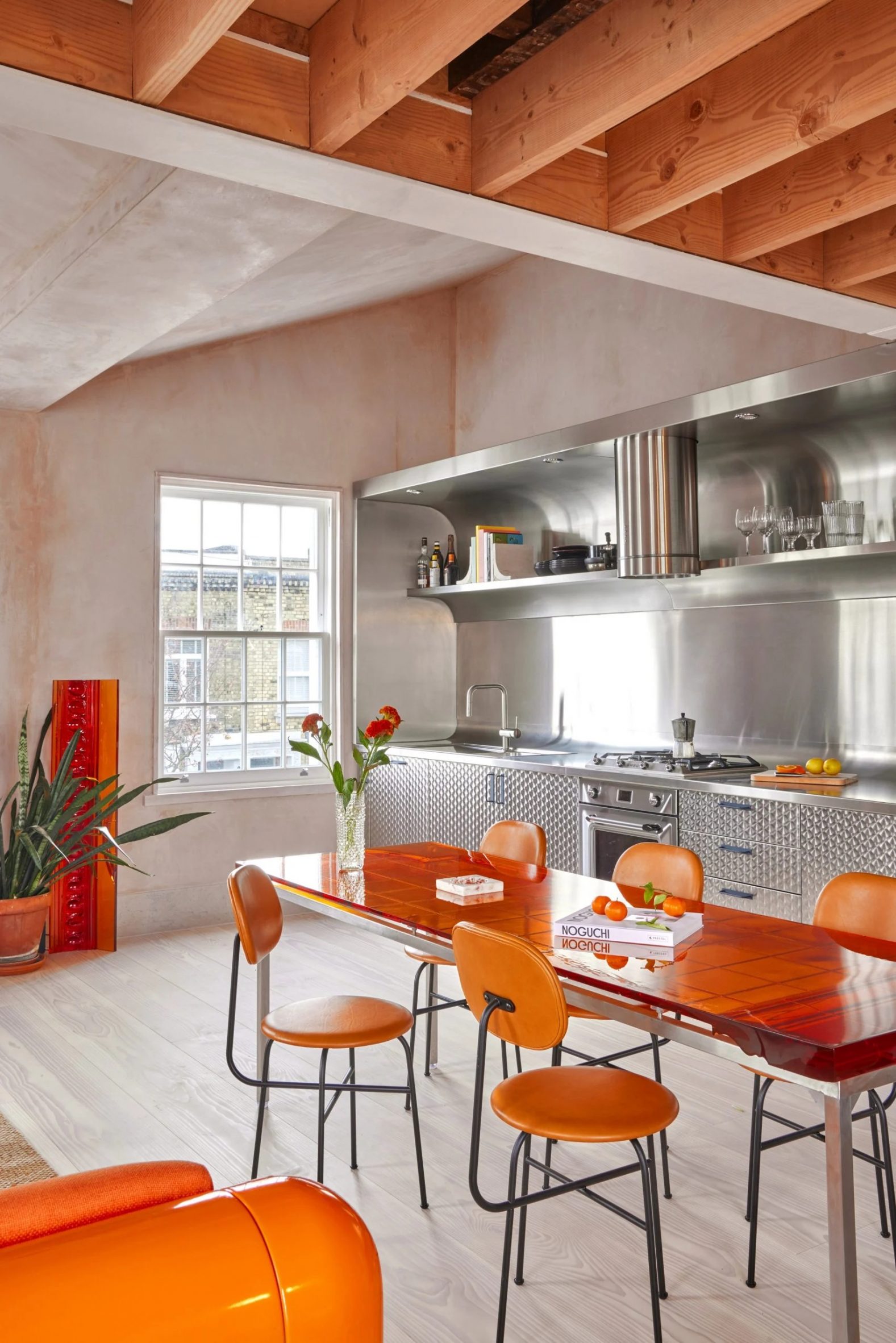 Kitchen with stainless steel counter and orange chairs