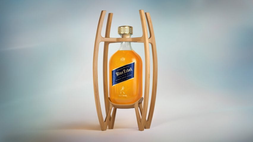 Photo of a thin glass Johnnie Walker bottle sitting within a bamboo cage structure