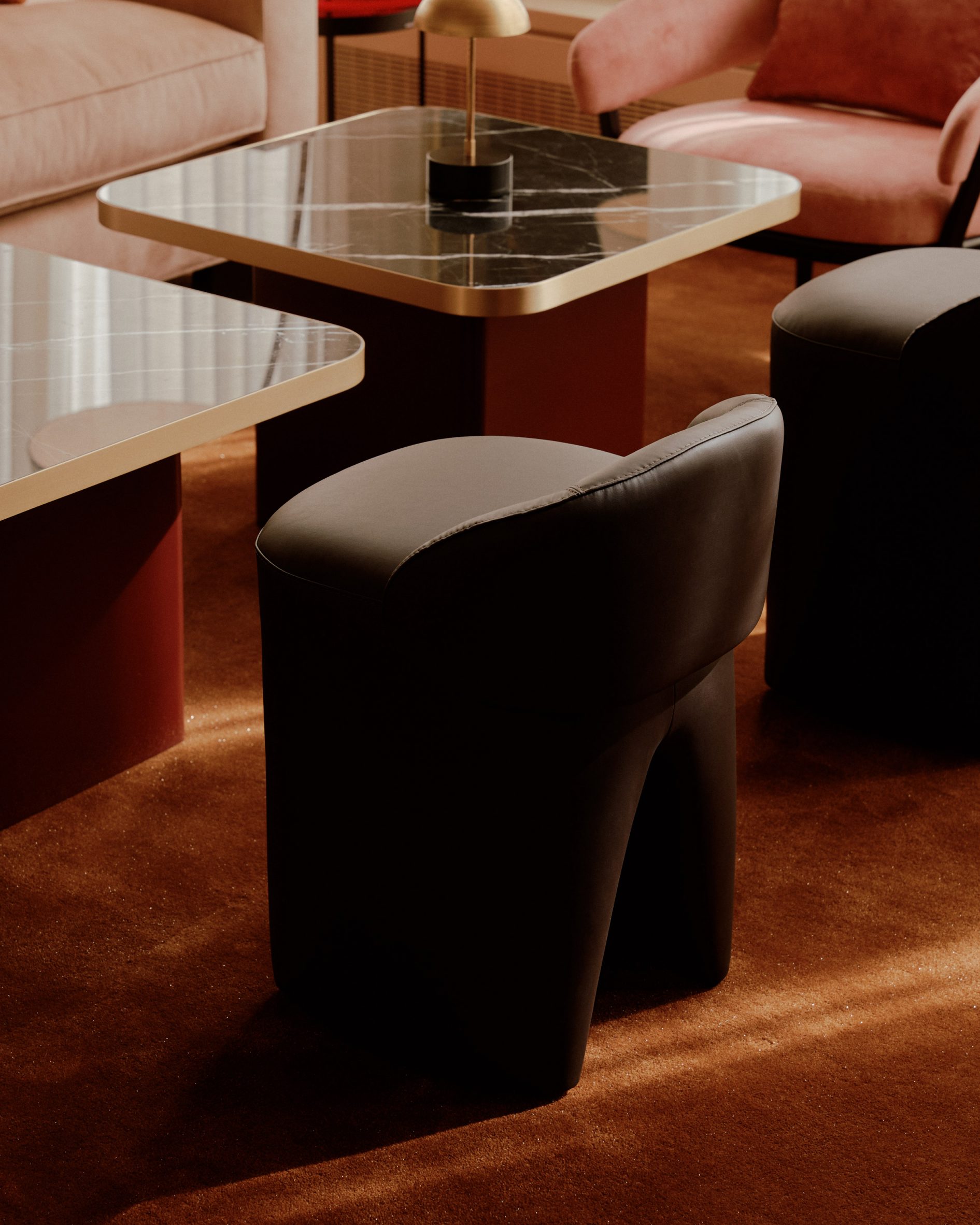 Black stools and black stone-topped tables on a rust carpet