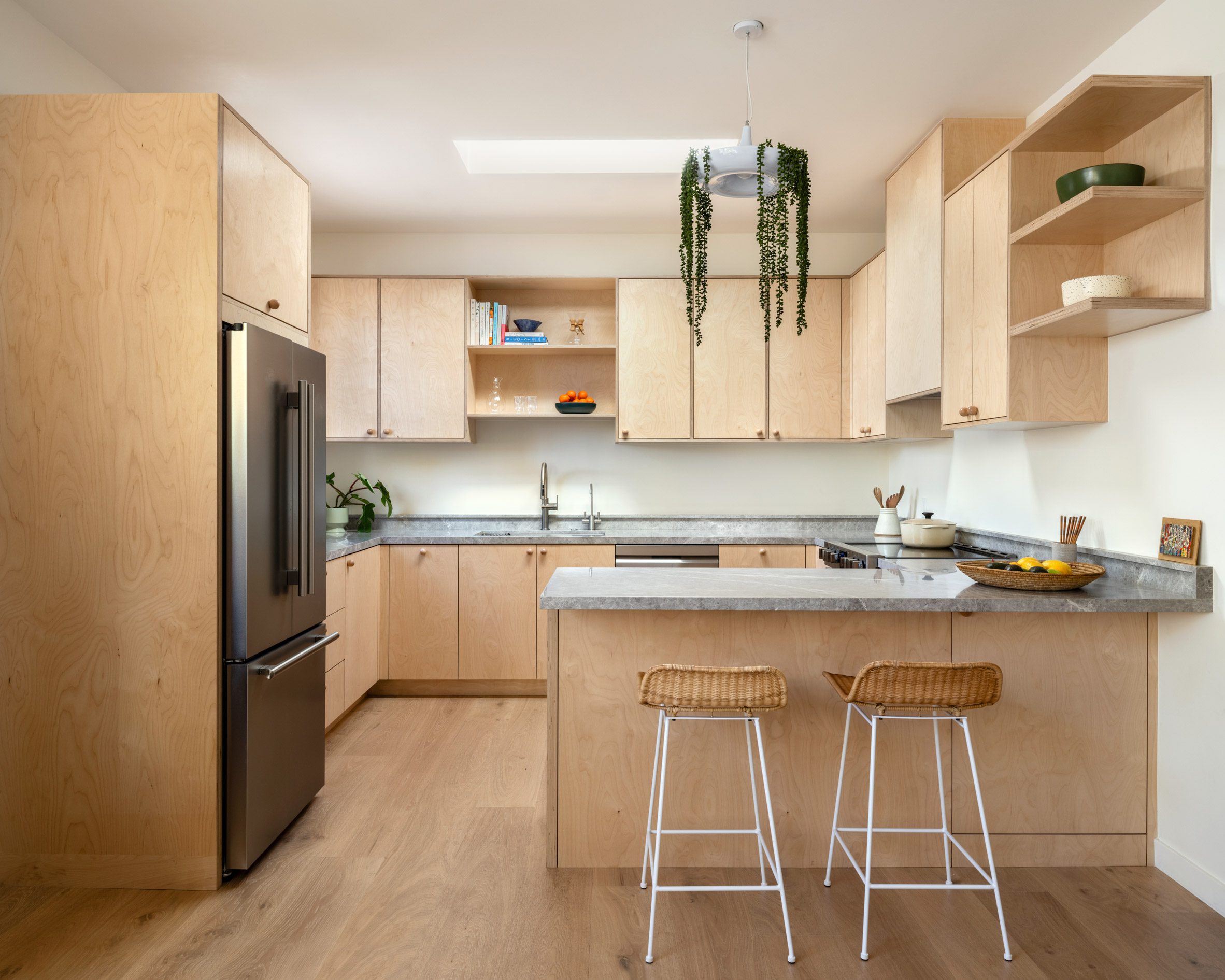 Kitchen with birch plywood millwork and grey marble counters