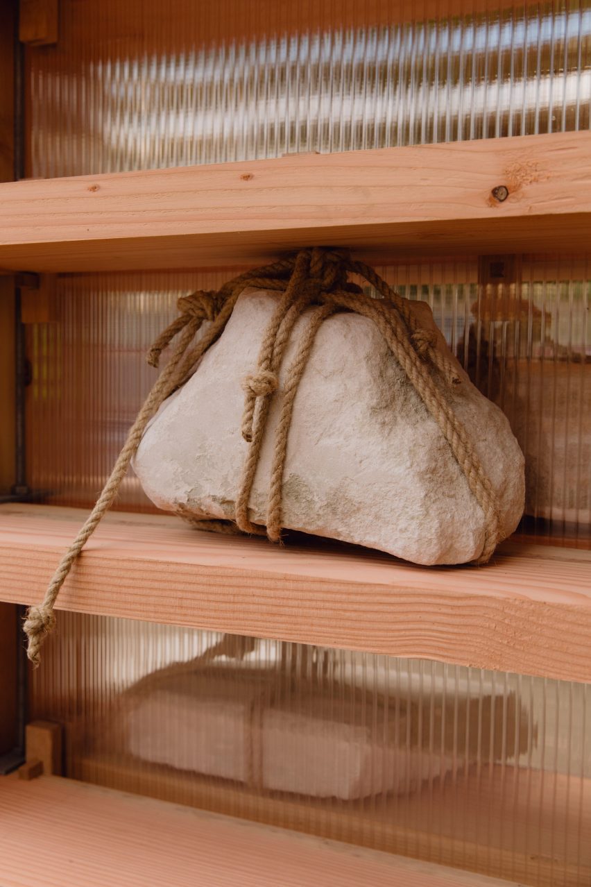 Close up of rock tied up in rope sitting on a shelf