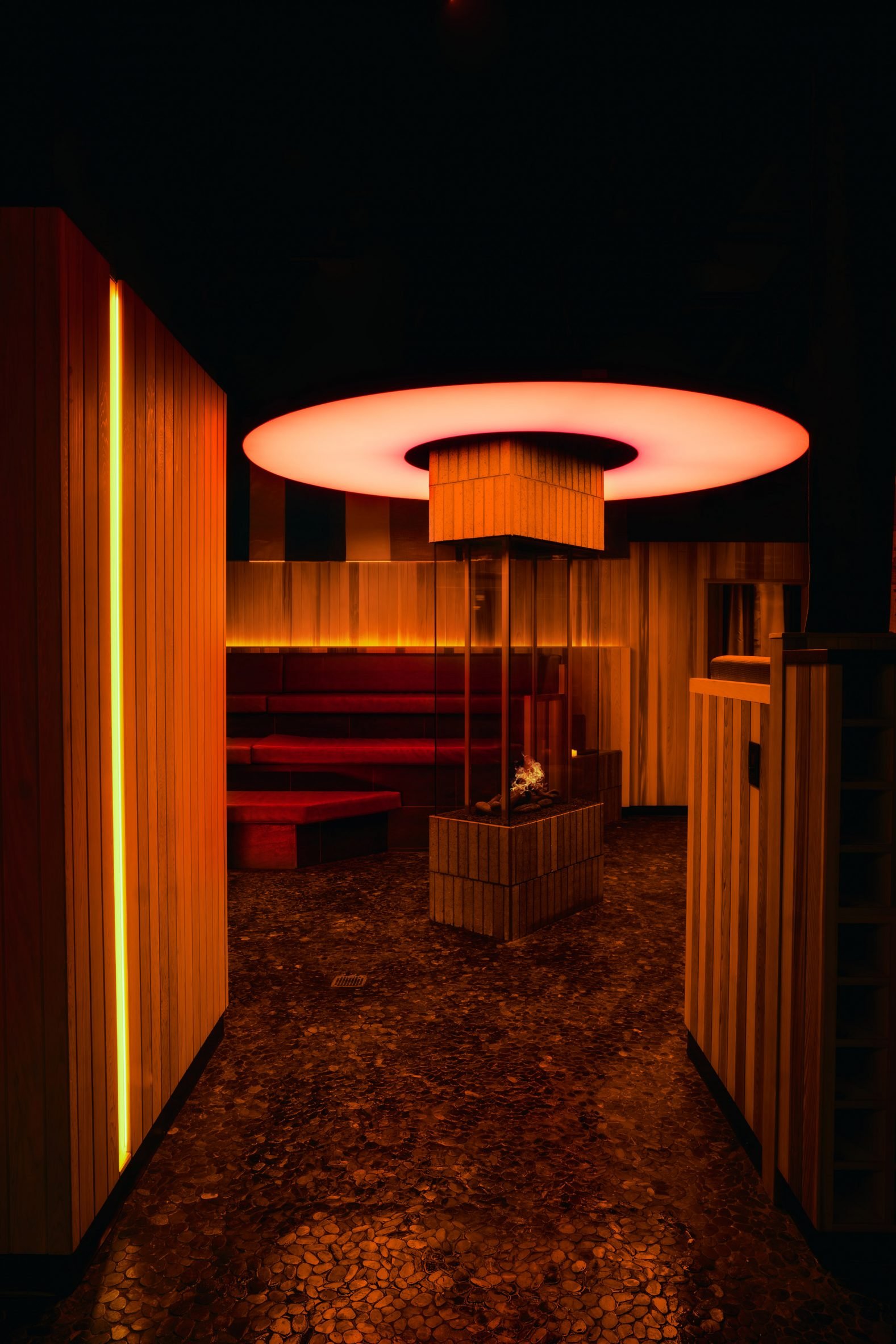 Fireplace illuminated by a custom halo-shaped light fixture