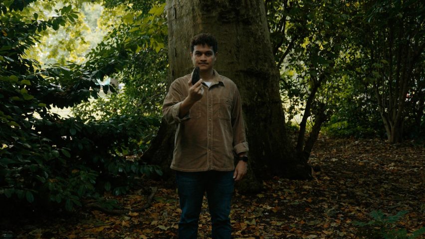 Photo of Richard Alexandre standing in a forest and holding the a wildfire detector