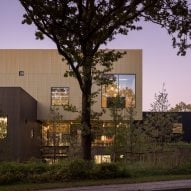 Rørbæk og Møller Arkitekter clads Danish university extension in gold-toned metal