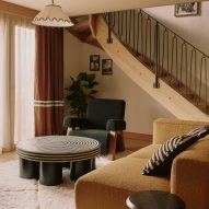 Sofa and coffee table with curving staircase behind