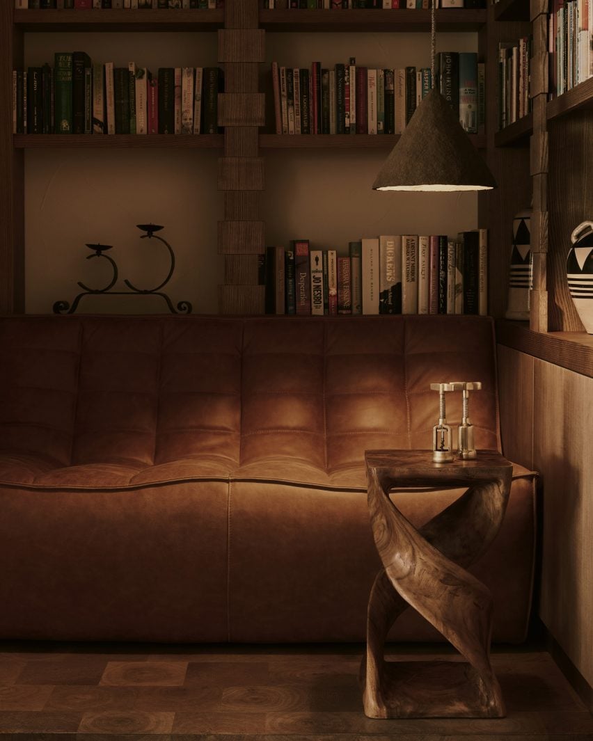 Secluded two-seater sofa tucked in a dimly lit nook off the main living area