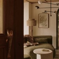 Brass fork handle on revolving door with sofa and coffee table in background