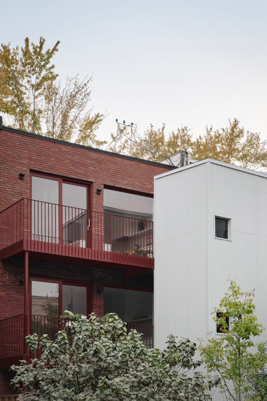 Red-brick building with burgundy window frames and balconies