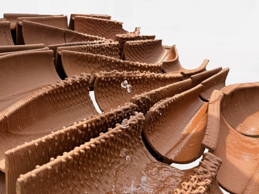 A photograph of brown ceramic curved structures, with water on them.