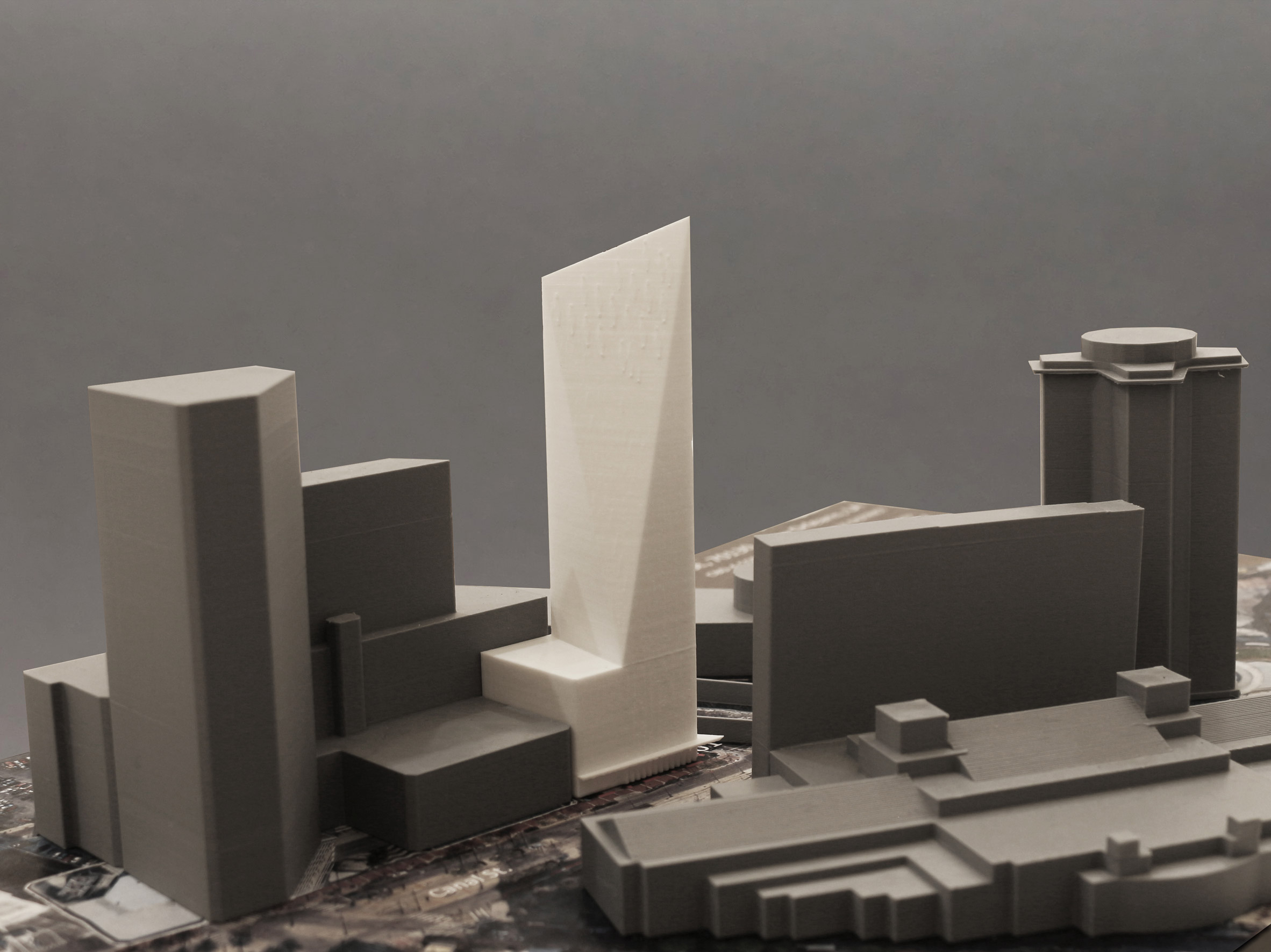 A photograph of architectural models of buildings in grey and white.