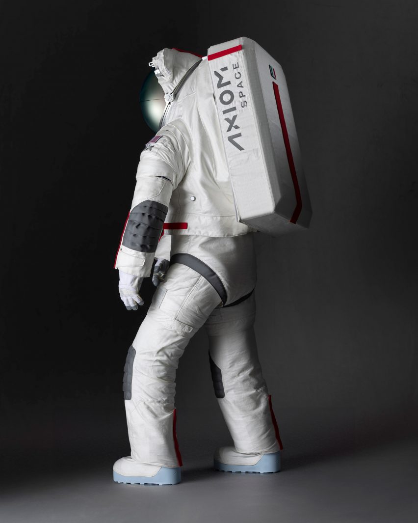 Side view photo of theAxEMU spacesuit showing a large tank on the back with the Axiom Space logo