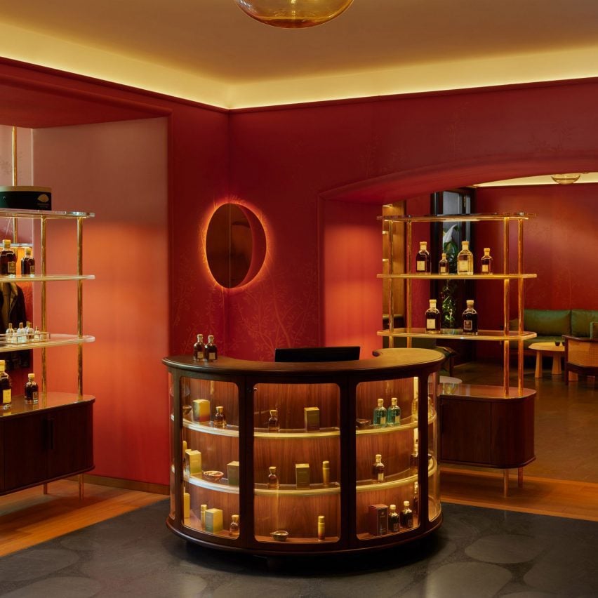 Photograph of a decorative red hotel interior with a curved bar unit.