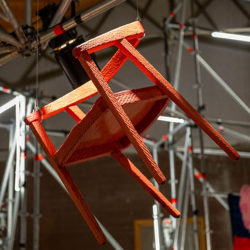 Red wooden chair hanging in installation