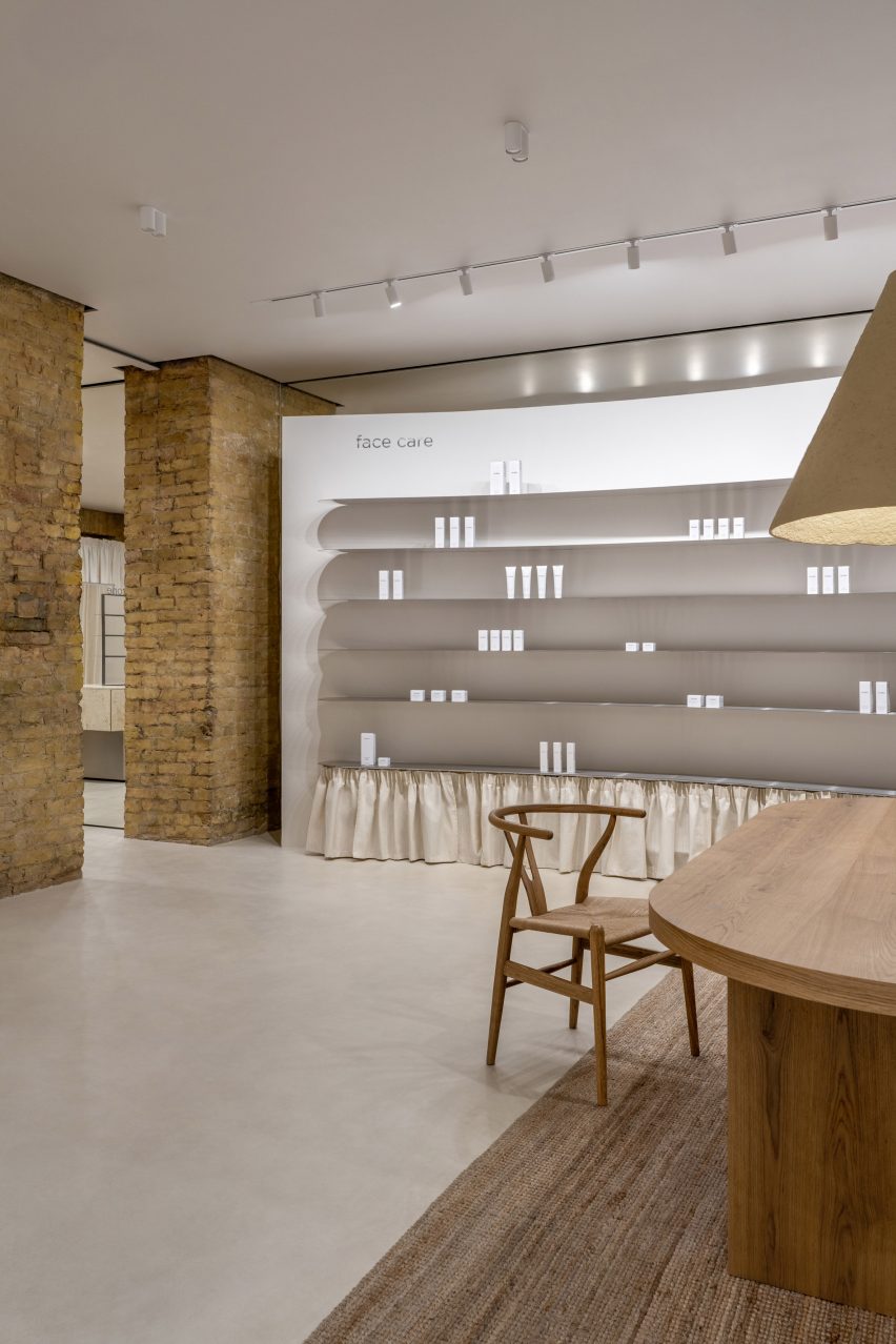 Photograph of a showroom interior with a minimalistic curved shelving unit.