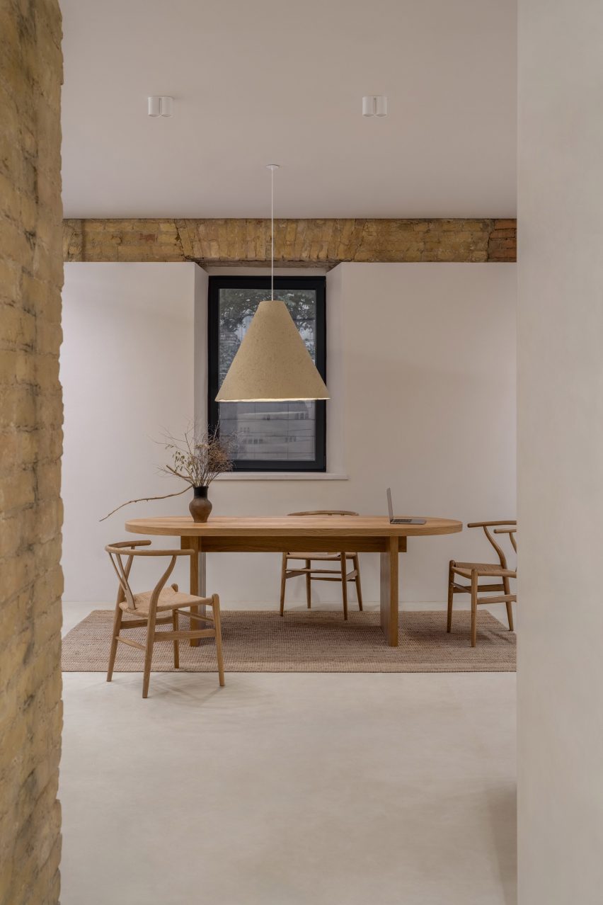 Photograph of a client meeting area with a large wooden table and wishbone chairs.