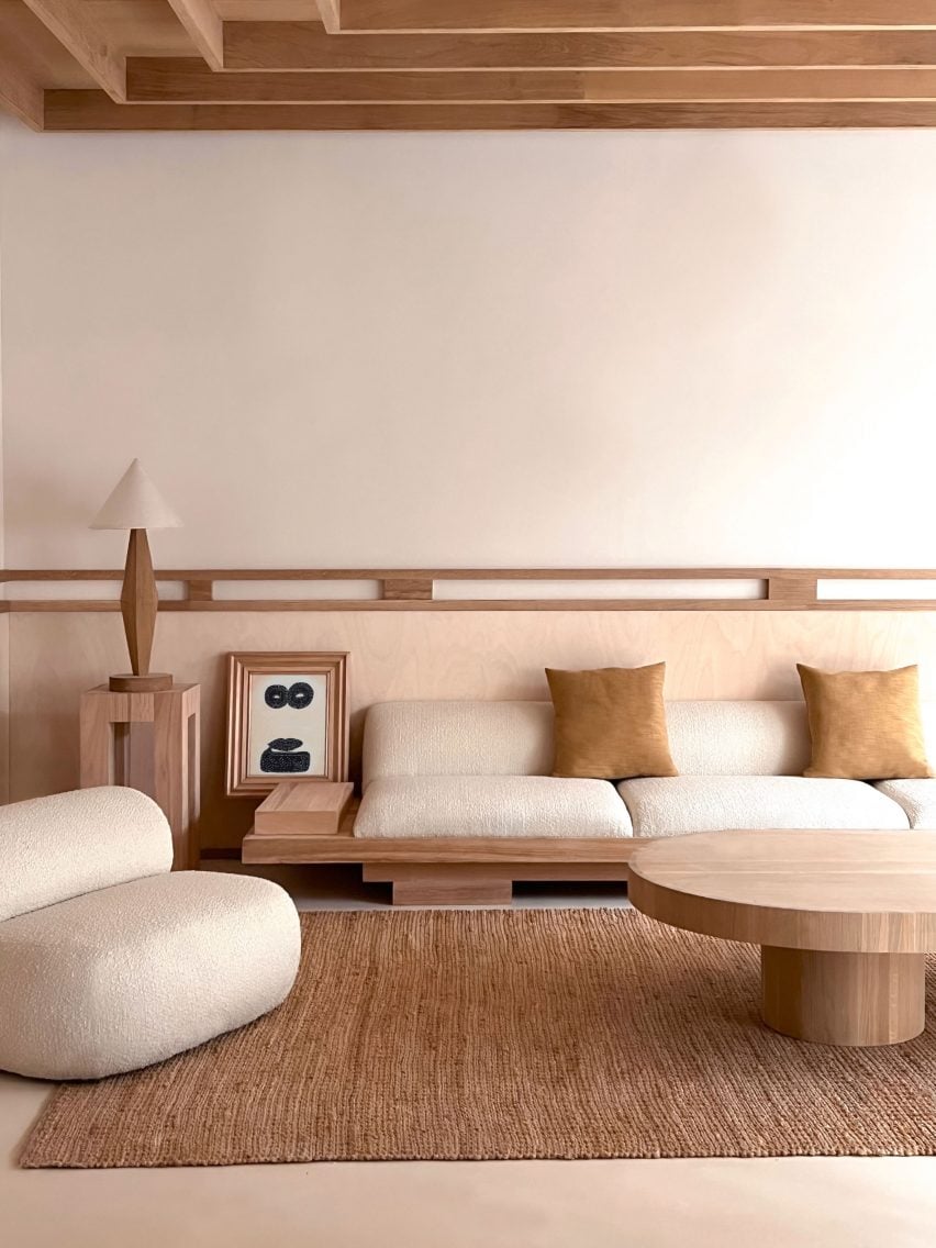 Photograph of a lounge area, showing furnishings mostly constructed from wood. 