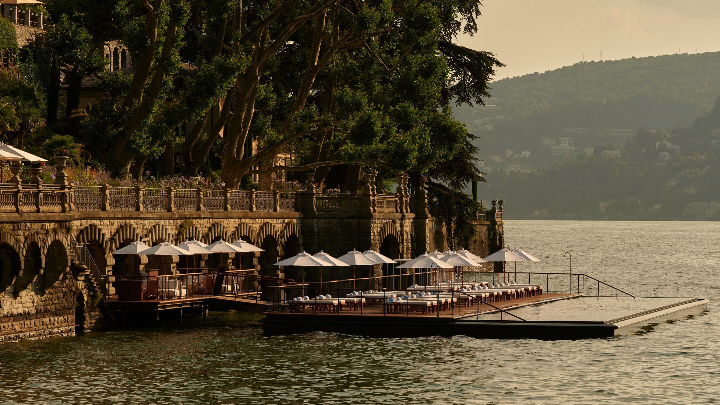 Photograph of an infinity pool belonging to a resort in Italy. The pool gives the illusion that is is blending into Lake Como.