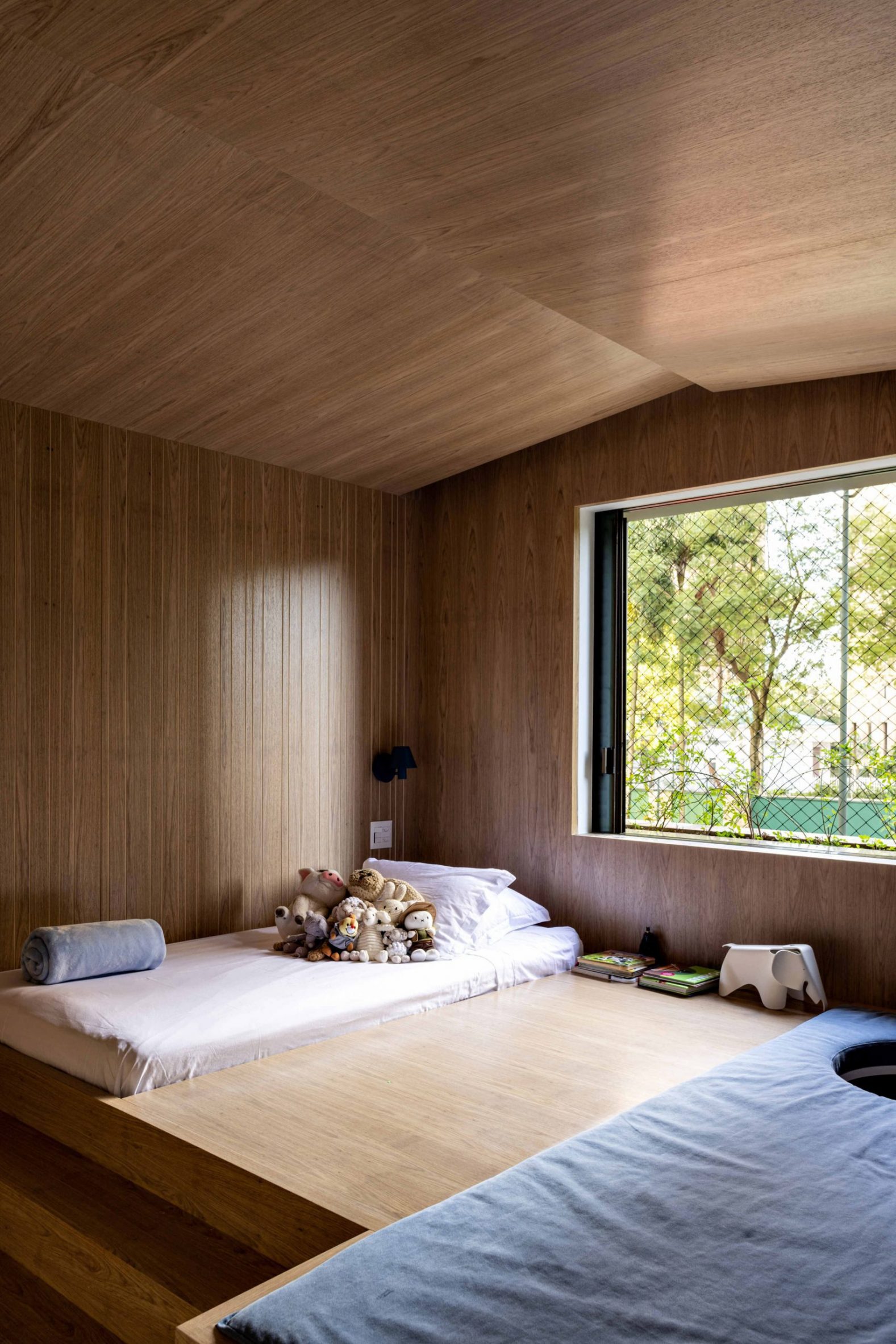 Child's bedroom with large window and wood walls