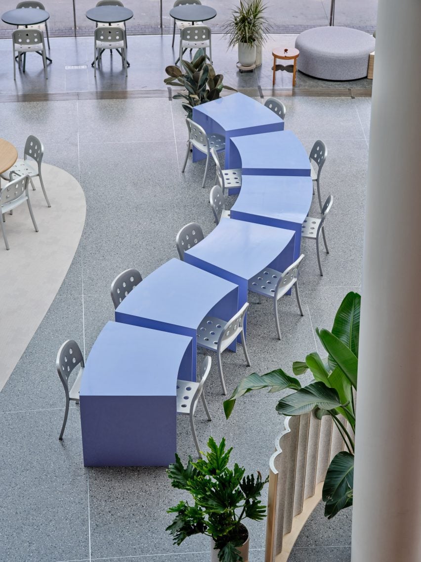 Row of periwinkle colored tables with sloping sides