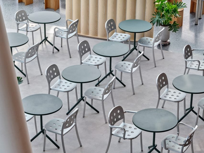 Dark green two-top tables accompanied by aluminium chairs 