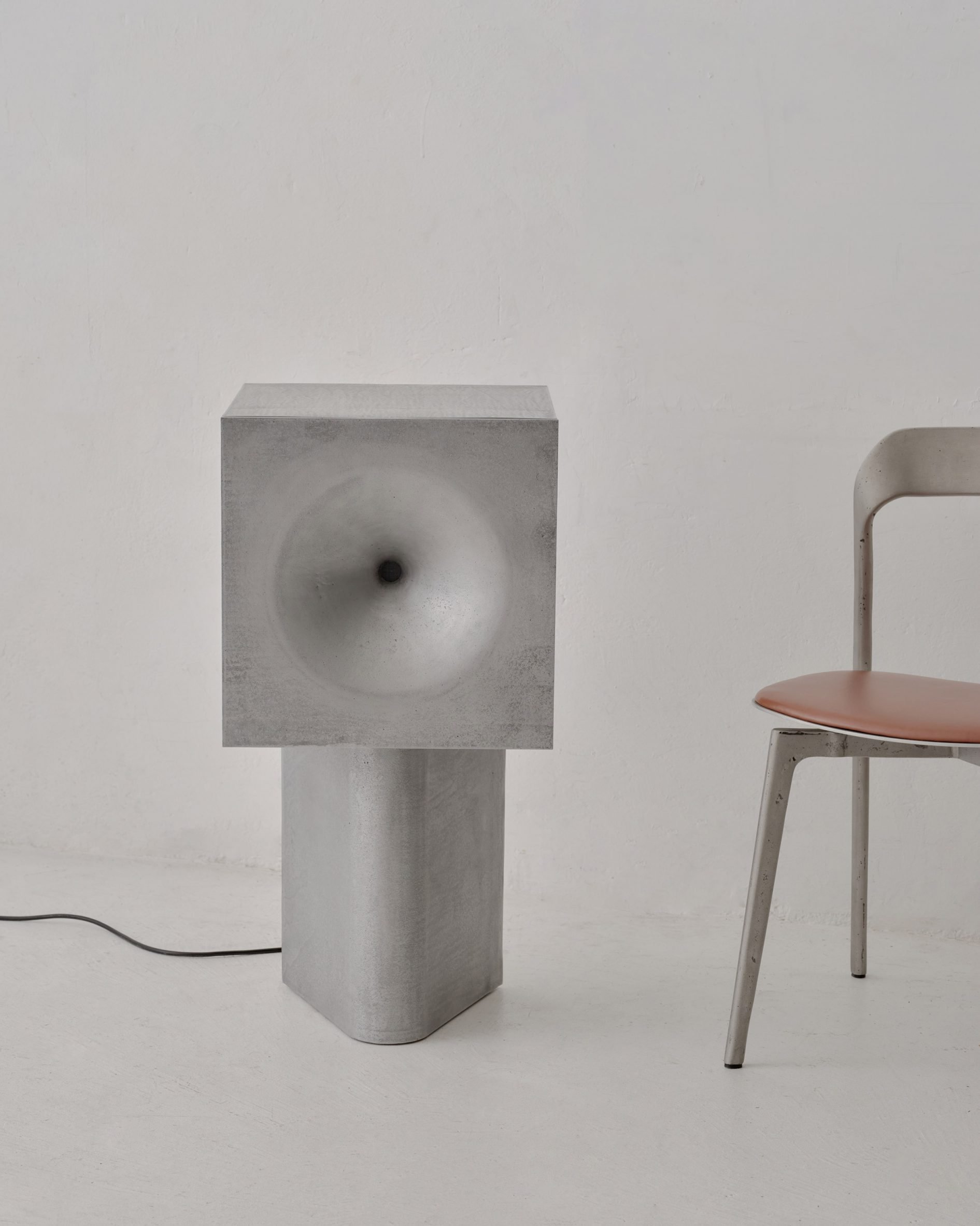 Cast speaker beside chair