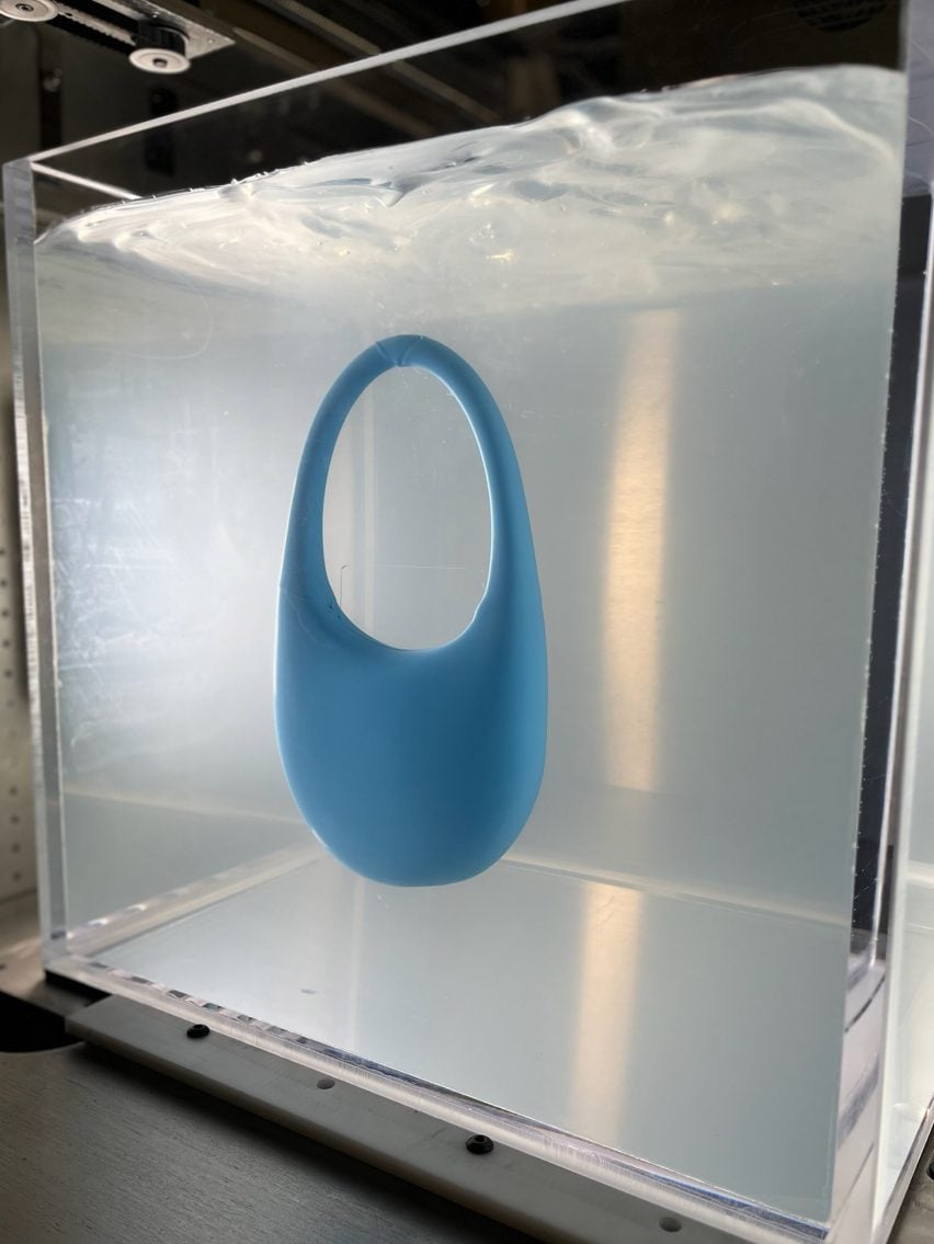 A photograph of a 3D-printed blue bag suspended in clear gel.