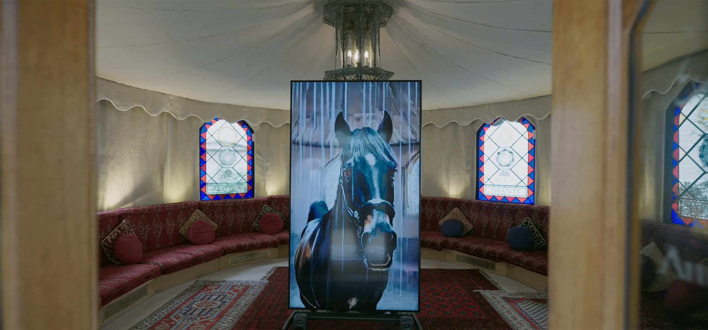 Tent interior with horse on screen in the middle of it