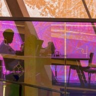 Woman sitting in front of pink panels