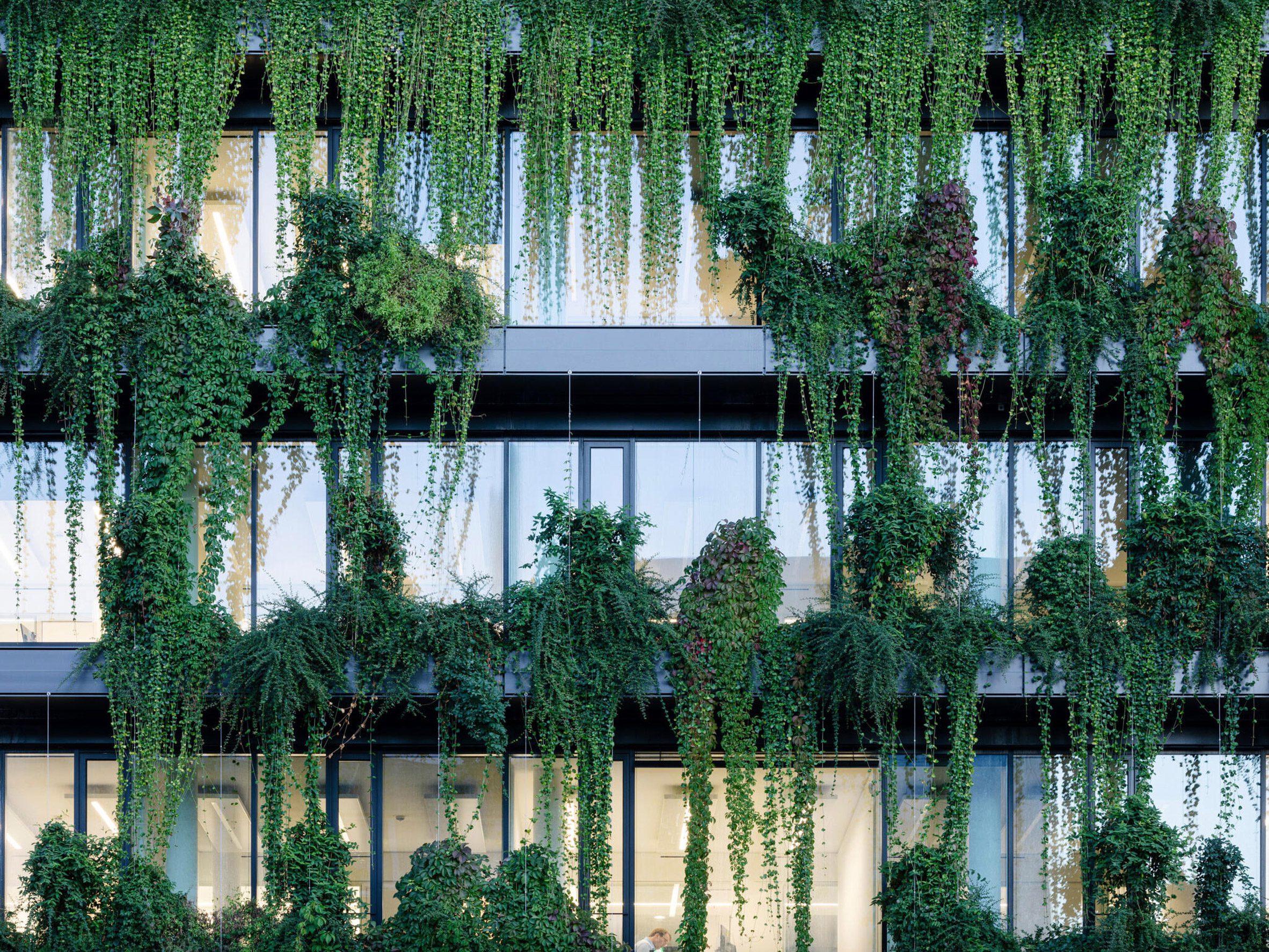 Plant-covered exterior of mixed-use building by Ingenhoven Associates