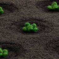 Rug with hand-tufted green plants set on top of a black backdrop