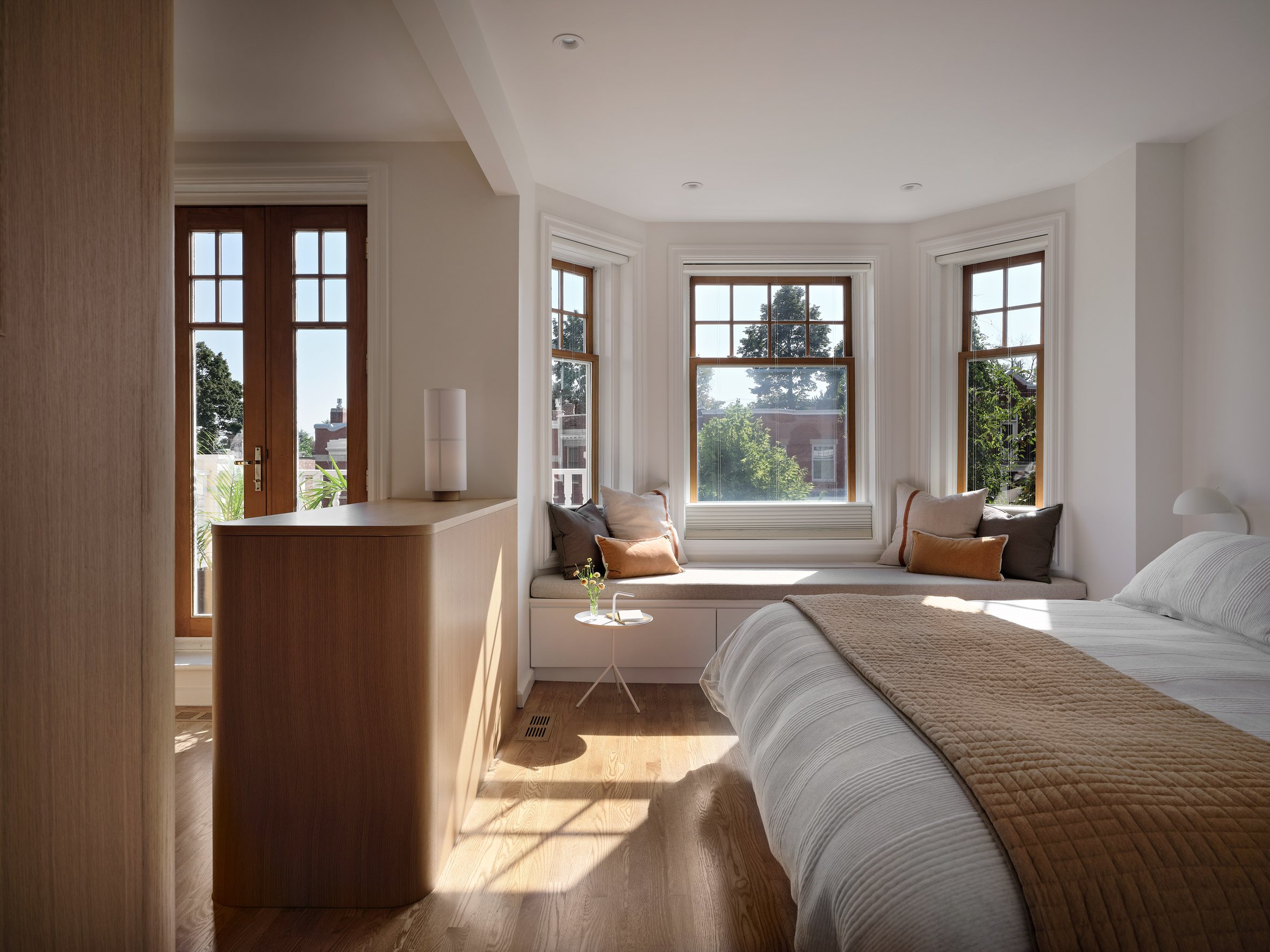 Primary bedroom with a bay window and a half-height divider