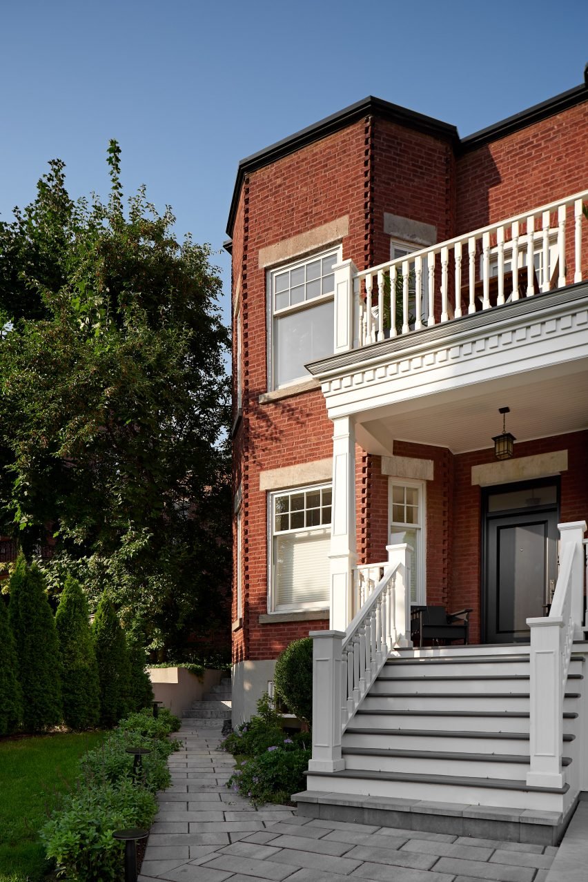 Exterior of a red-brick home with a white-painted front porch