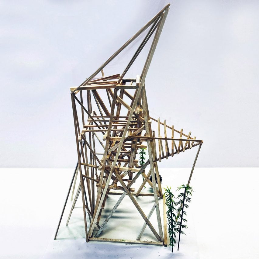 A photograph of an architectural model made from brown wooden sticks, in a geometric shape, against a white backdrop.