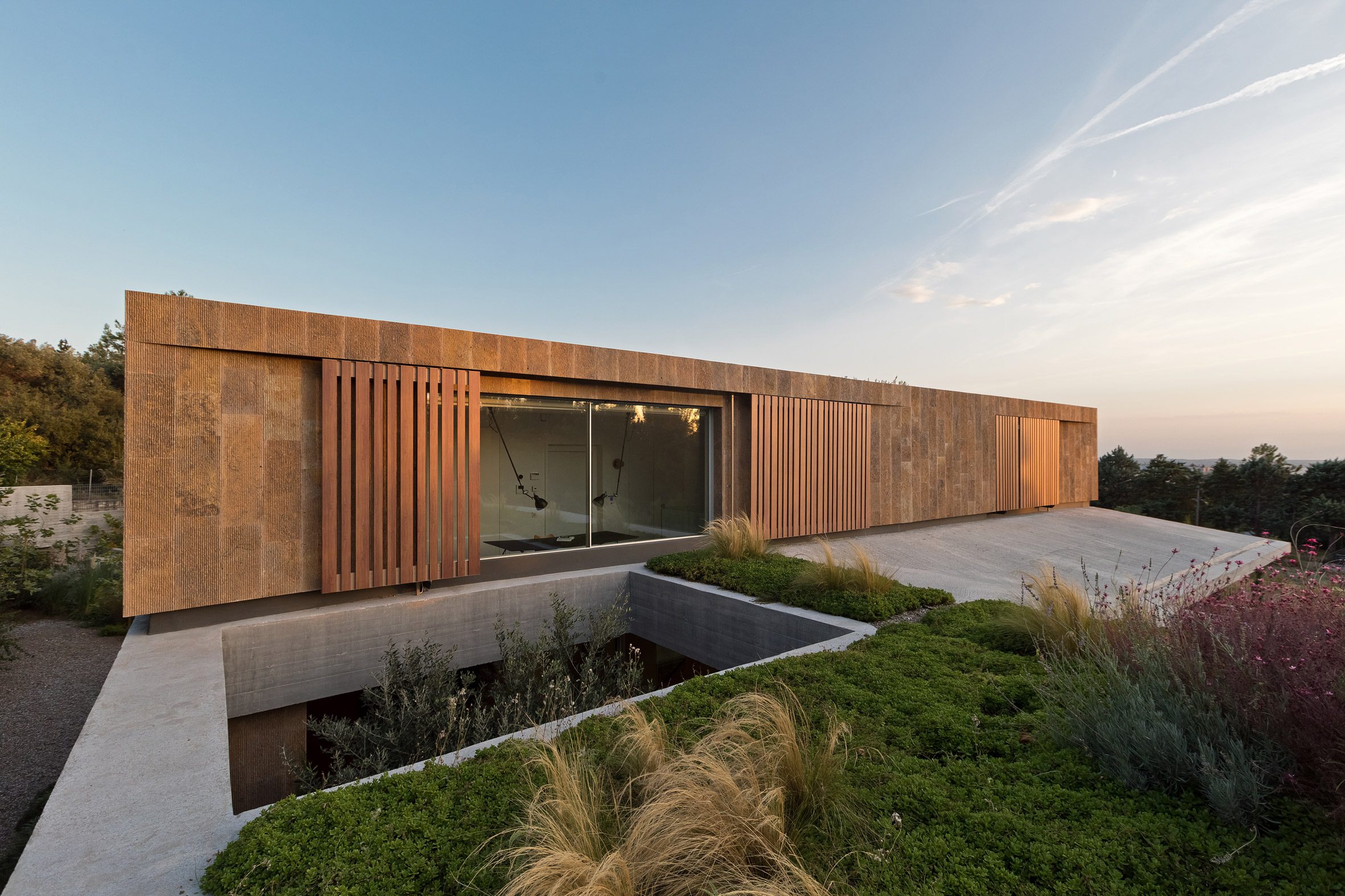 Upper floor exterior of stone house by Point27 Architects