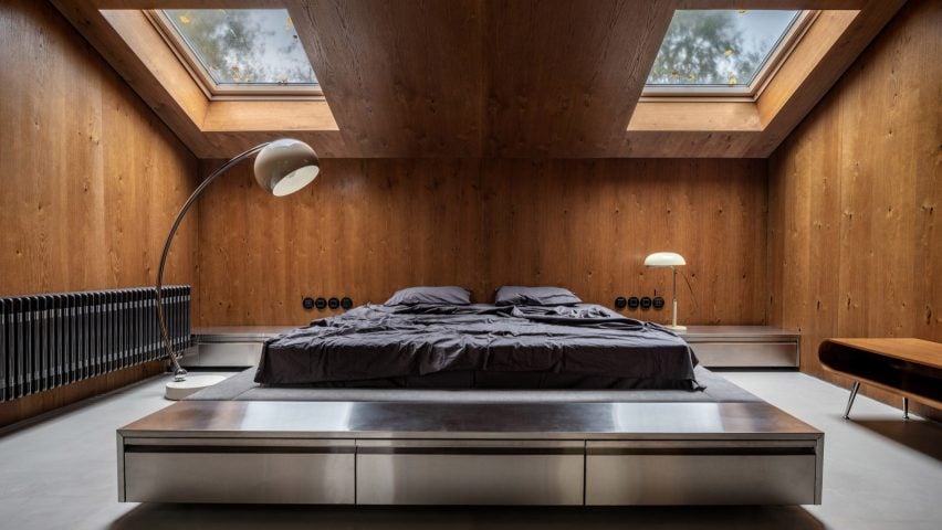 Bedroom in Ukraine with wood panelling and skylights